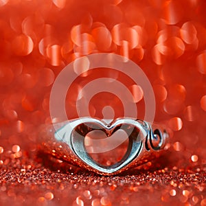 Heart ring on the floor with red bokeh on background