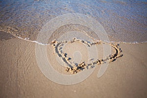 Heart in sand at the beach, confession of love, summer, sea and sun photo