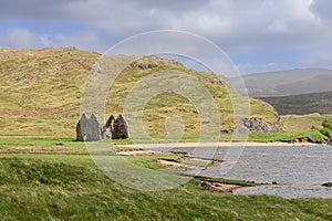 In Scottish Highlands, weathered Calda House ruins stand, surrounded by verdant fields and hills photo