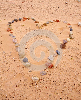 Heart of sea stones on sand