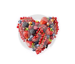 Heart shape assorted berry fruits on white background. Berries in heart shape isolated on a white. Ripe blueberries, red currants,