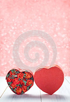 Heart shape box with red roses inside on white wood table top at photo