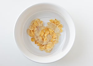 Heart shape cornflake in white bowl isolated