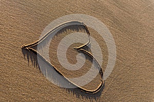 Heart shape drawn in the sand on a beach