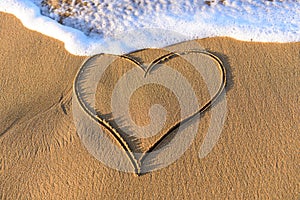 Heart shape drawn in the sand on a beach