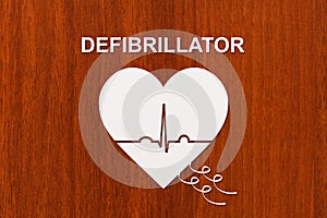 Heart shape with echocardiogram and DEFIBRILLATOR text. Cardiology concept