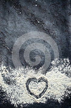 heart shape and flour on the dark table. Baking background. vertical image. top view. place for text