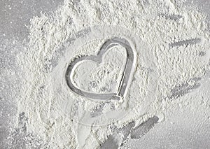 Heart shape in flour on grey kitchen table