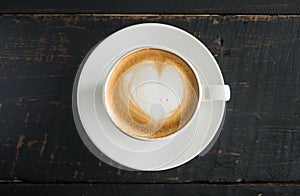 Heart Shape Froth Milk Latte Art in White Coffee Cup on Black Wood Table