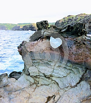 Heart shape geological formation naturally occurring in lava rock wall at Nakalele in Hawaii, USA