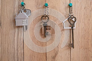 Heart shape house key with home keyring on wood fence background