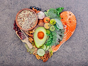 Heart shape of ketogenic low carbs diet concept. Ingredients for healthy foods selection on dark stone background