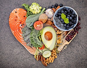 Heart shape of ketogenic low carbs diet concept. Ingredients for healthy foods selection on dark stone background. Balanced