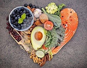 Heart shape of ketogenic low carbs diet concept. Ingredients for healthy foods selection on dark stone background. Balanced