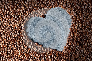 Heart shape made from brown and black roasted coffee beans or grains background