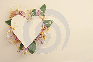 heart shape made of colored cardboard hiding caprifoi flowers. photo