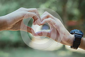 Heart shape made with hands of female student, Love symbol concept.