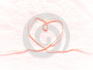 Heart shape made from hemp rope on softness cotton white background.