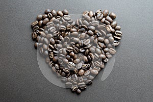 Heart shape made of roasted coffee beans on dark background