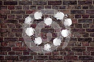 heart shape made of snowballs on brick wall