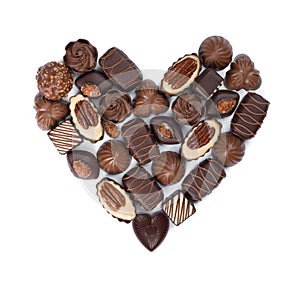 Heart shape made from various chocolate bonbons isolated on white