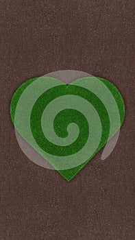 Heart shape of meadow green grass surface isolated on soil ground surface. Turf and terrain blank top view background. Gardening