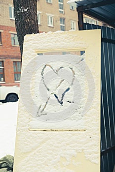 A heart shape painted in the snow on a discarded door