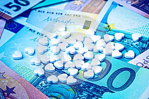 Heart-shape pills on the background of euro bills. The concept of the expensive cost of healthcare