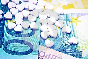 Heart-shape pills on the background of euro bills. The concept of the expensive cost of healthcare