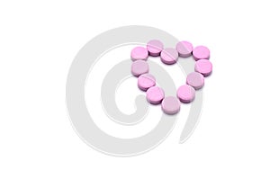 Heart shape of pink pills isolated on white background.