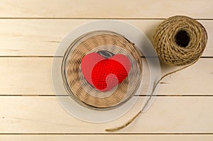 heart shape with roll of twine cord on blank wooden board , vale