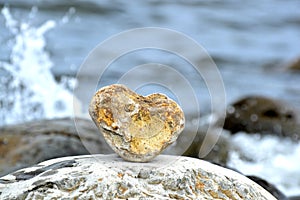 Heart shape stone against background of beach. Summer sunny day. Love, wedding and Valentine day concept. Finding