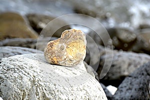 Heart shape stone against background of beach. Summer sunny day. Love, wedding and Valentine day concept. Finding