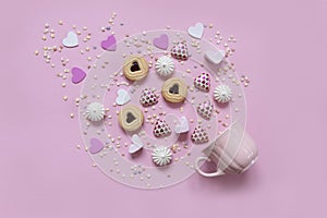 Heart shape sweets and confections and pink mug on pink background. Top view, close-up, valentine`s day concept