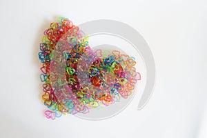 Heart shape on white background from stacking of multi colour heart shaped plastic chain.