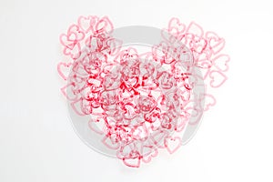 Heart shape on white background from stacking of multi colour heart shaped plastic chain.