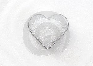 Heart shape by white granulated sugar on the pile sugar background for valentines day and love element concept design.