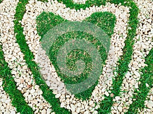 Heart shape white stones on the grass for landscape design. Backdrop for Valentineâ€™s day or romantic background for wedding card