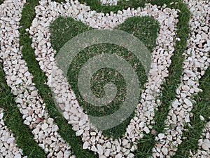 Heart shape white stones on the grass for landscape design. Backdrop for Valentineâ€™s day or romantic background for wedding card