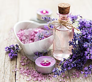 Heart-shaped bowl with sea salt, oil and fresh lavender flowers