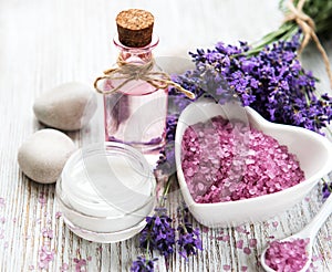 Heart-shaped bowl with sea salt, oil  and fresh lavender flowers