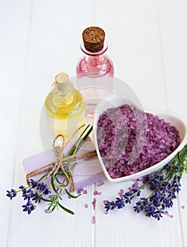 Heart-shaped bowl with sea salt, soap and fresh lavender flowers