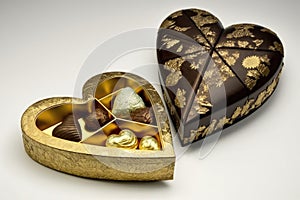 heart-shaped box filled with handmade truffles and confections, wrapped in gold or silver foils