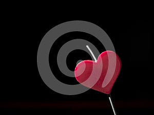 Heart shaped candle. Black background