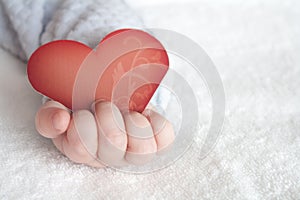 Heart shaped card in baby hand