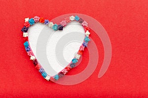 Heart-shaped card with frame of hearts on redbackground. photo