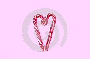 Heart shaped christmas candy on a pink background.