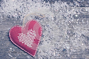 Heart shaped christmas decoration on snowy wooden background