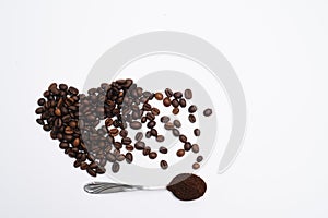 Heart shaped coffee beans with grounds and spoon