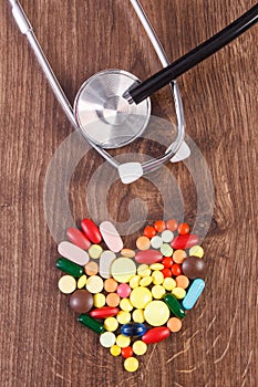 Heart shaped colorful medical pills and capsules with stethoscope, health care concept